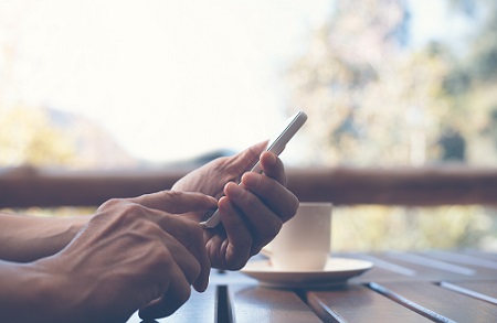 Hænder der holder en mobiltelefon