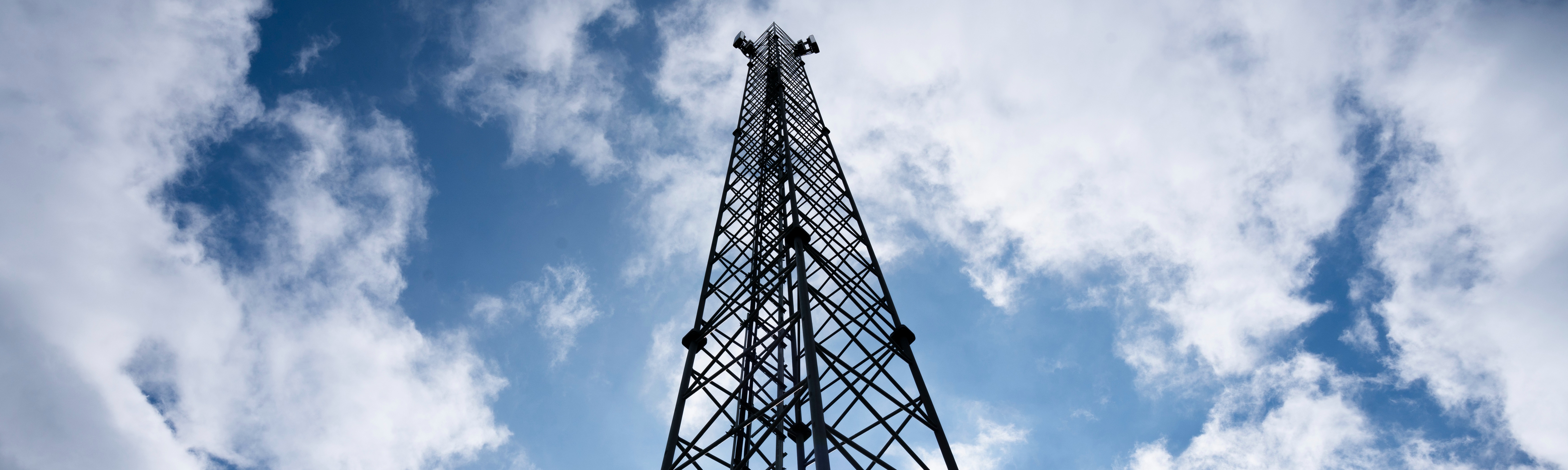 En 5g mast nedefra med himlen som baggrund