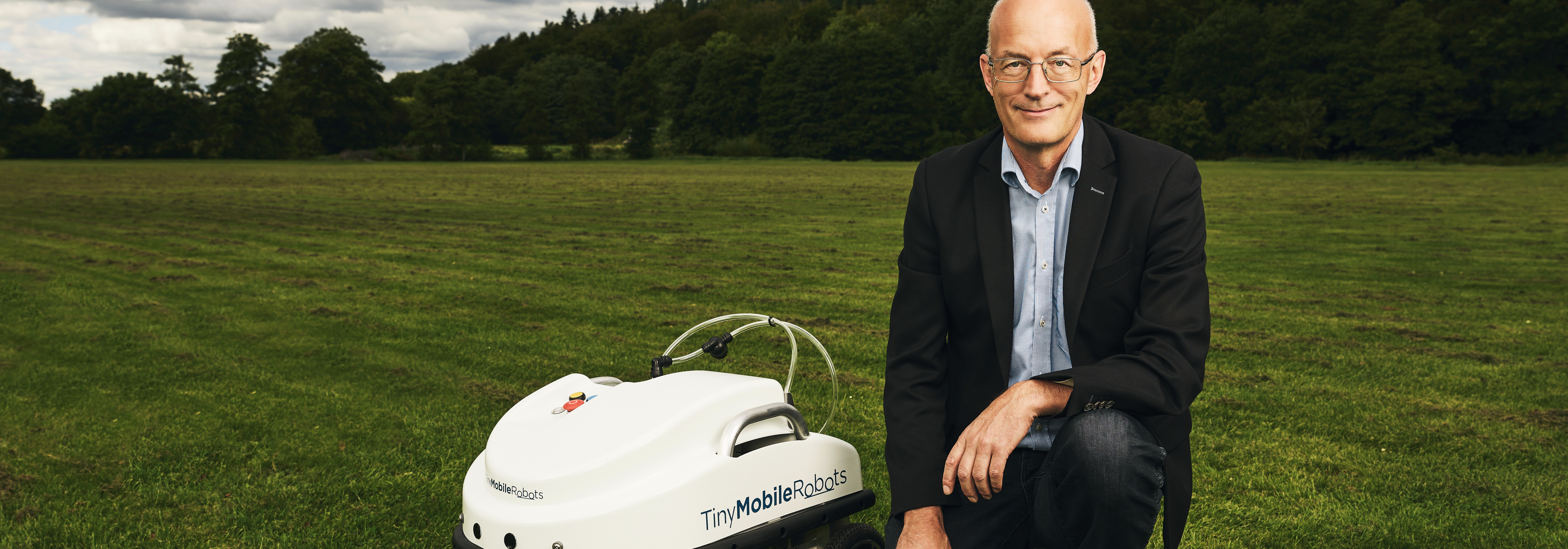En mand fra Tiny mobile robots ved siden af en robot

