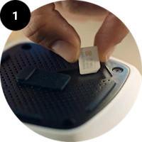 En finger indsætter et SIM-kort i en mobiltelefon eller enhed med en sort SIM-kortholder.