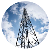 Billedet viser en cirkel med baggrunden af en mast og himmel med skyer, billedet bliver set nede fra og op