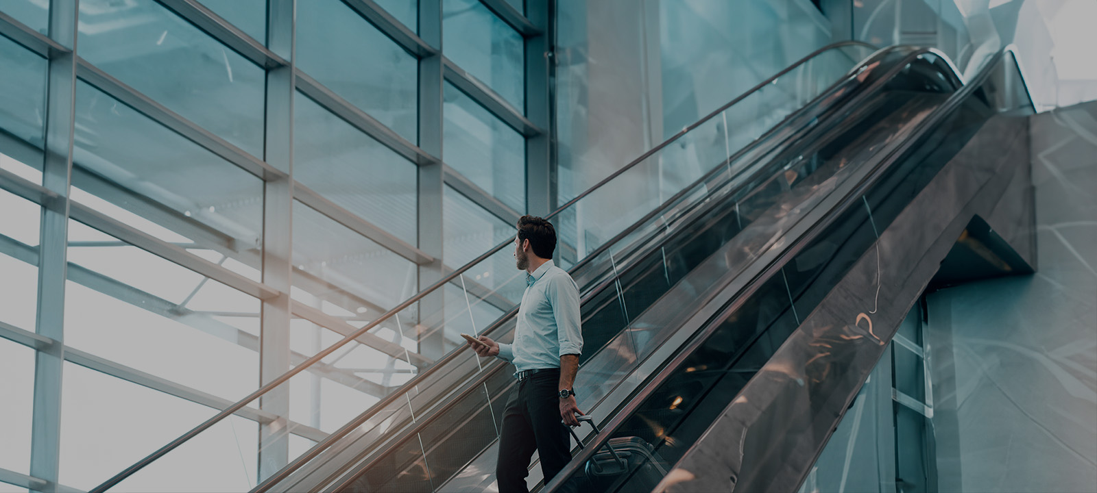 Udlandstelefoni "Mand på rulletrappe med telefonen i hånden"